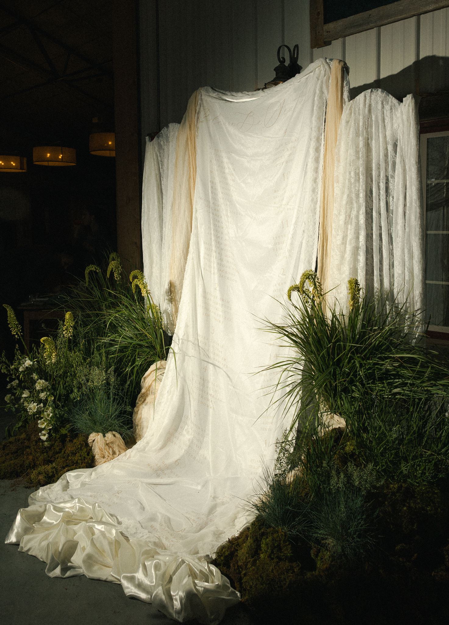 Draped ivory fabric displayed among grasses at dusk