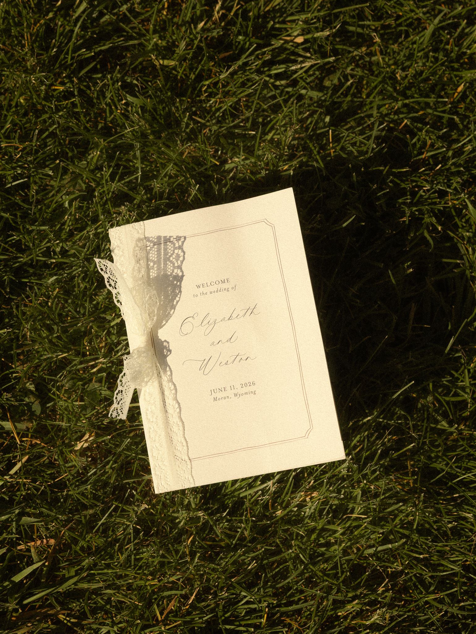 Wedding welcome card with lace ribbon on the grass